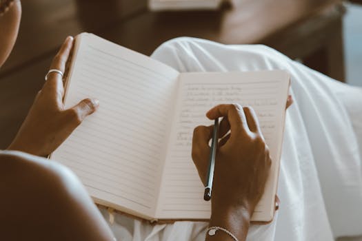 person writing goals in a notebook