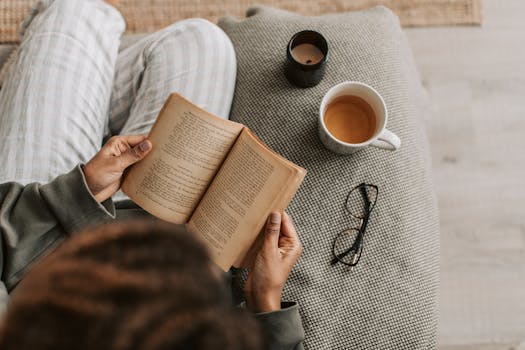 a person relaxing with a book and a cup of tea